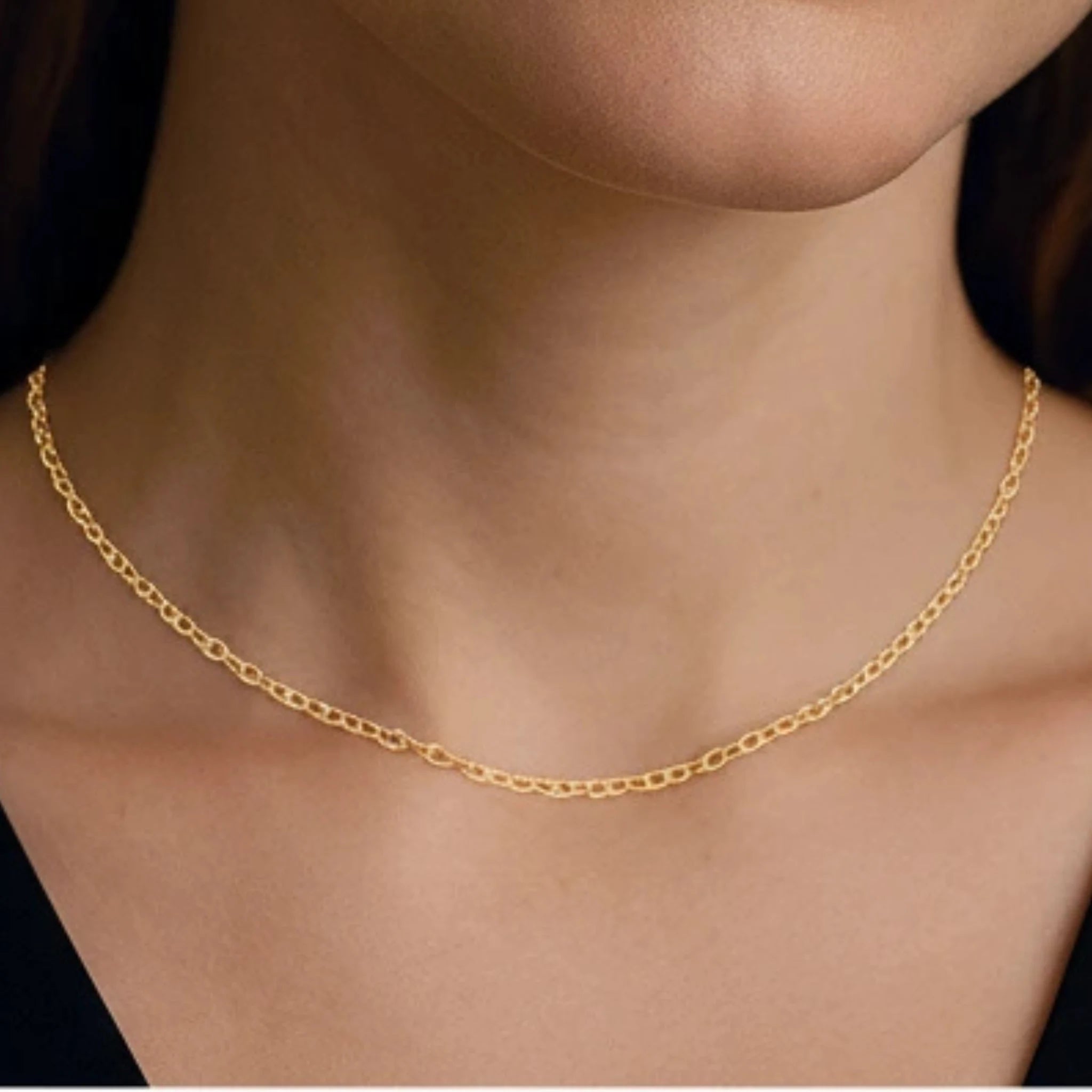 Classic chain choker on a person's neck with a black shirt