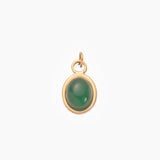 Golden pendant with a emerald green stone on a white background