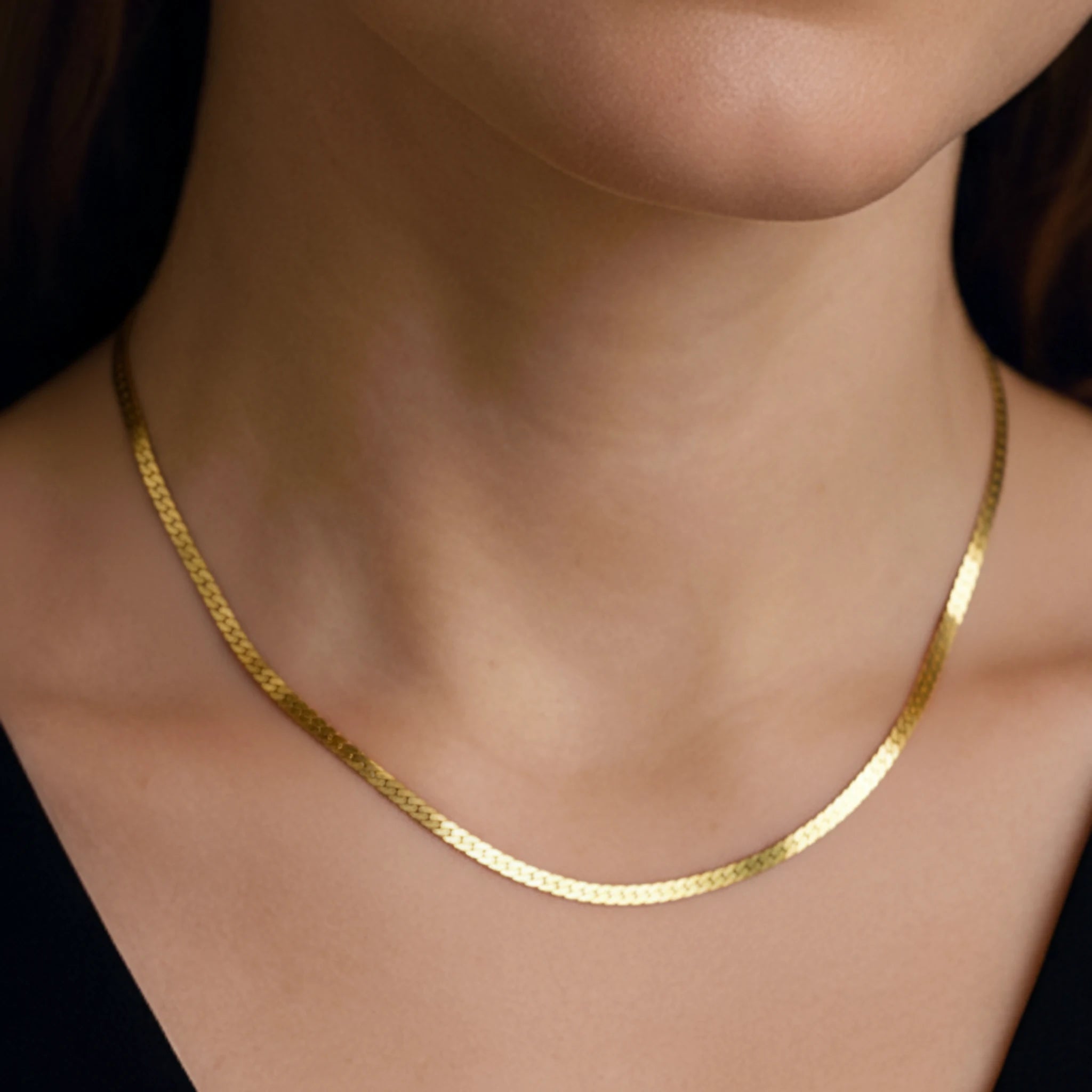 Flat chain medium necklace on a person wearing a black top