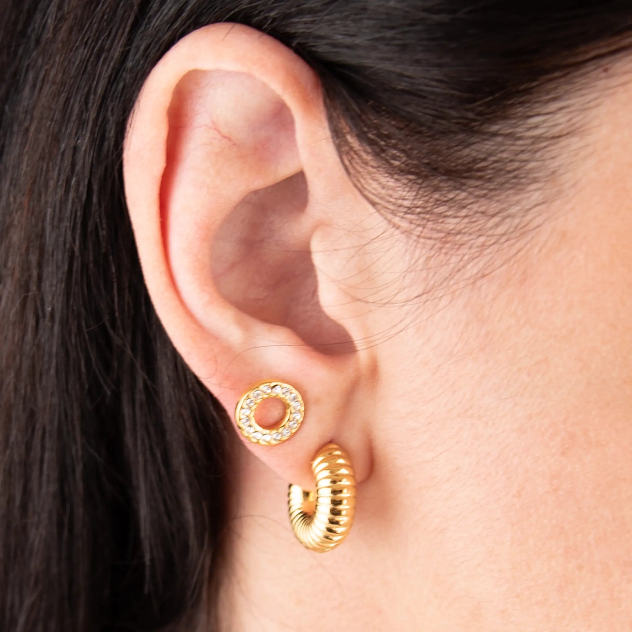 Golden duo set spiral and crystal worn by a person.