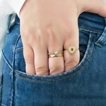 Hand with gold rings on a blue denim background
