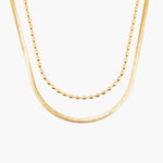 Two gold necklaces on a white background