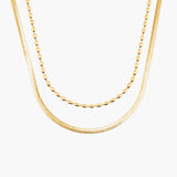 Two gold necklaces on a white background
