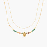Golden necklace with colorful beads and a sun charm on a white background