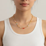 A woman wearing a color chain necklace and a white top