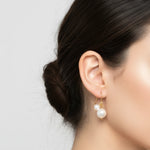 Pearl earring worn by a person with a neutral background