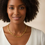 A woman wearing a U-link chain necklace against a beige background